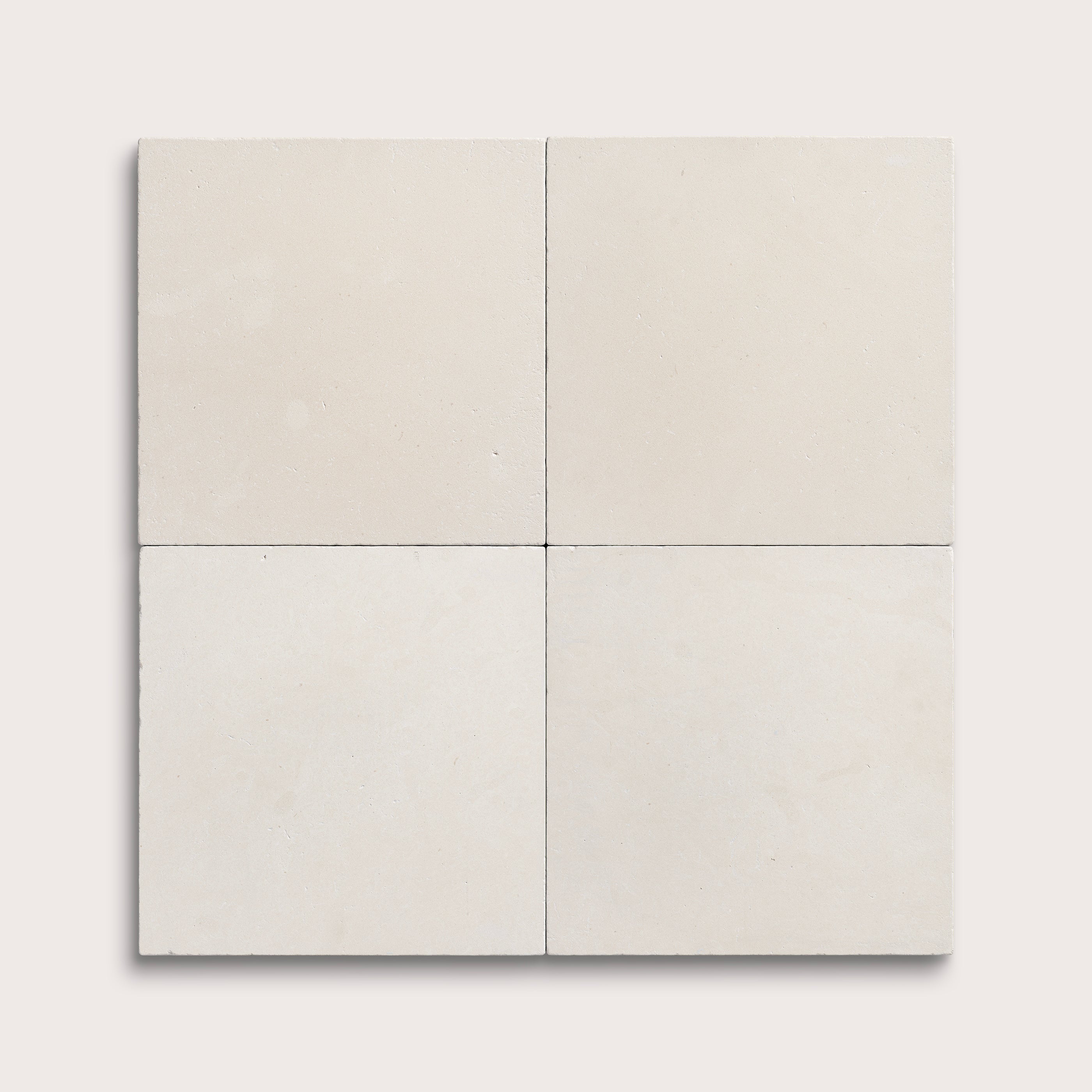 four square tiles with a white limestone pattern on a white background