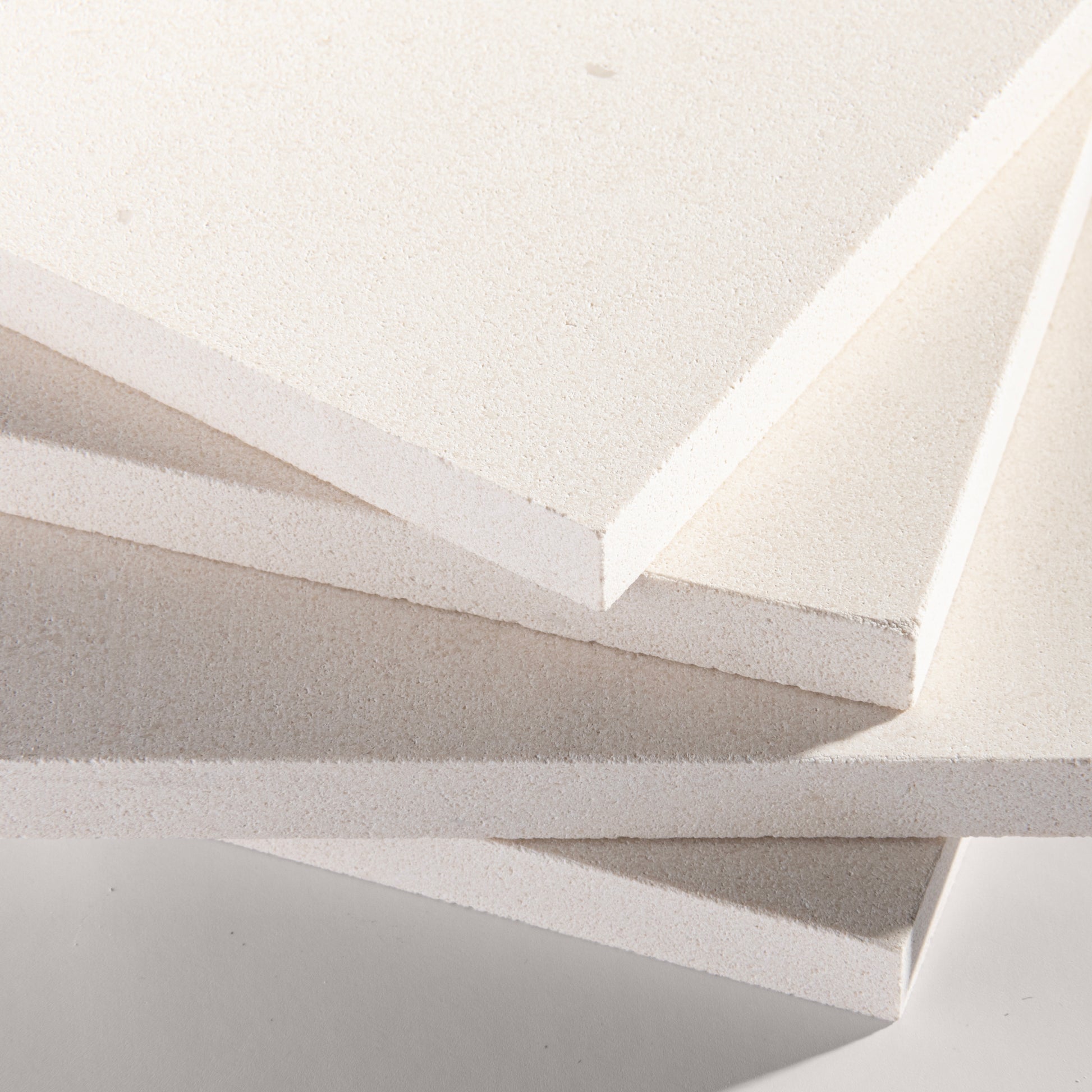 close up angle of tiles with a white limestone pattern on a white background