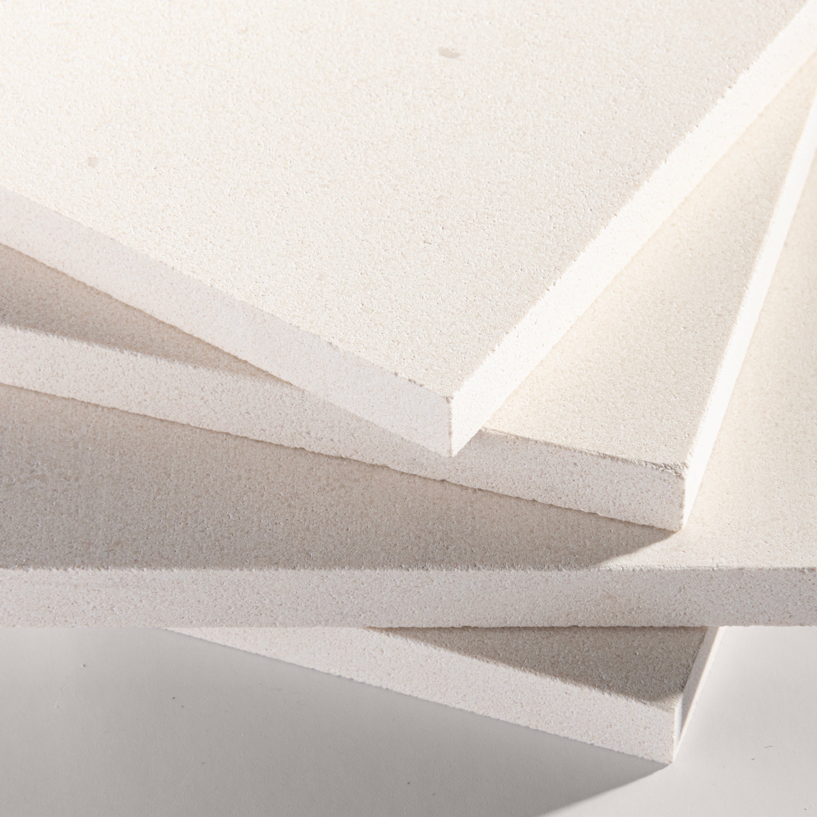 close up angle of tiles with a white limestone pattern on a white background