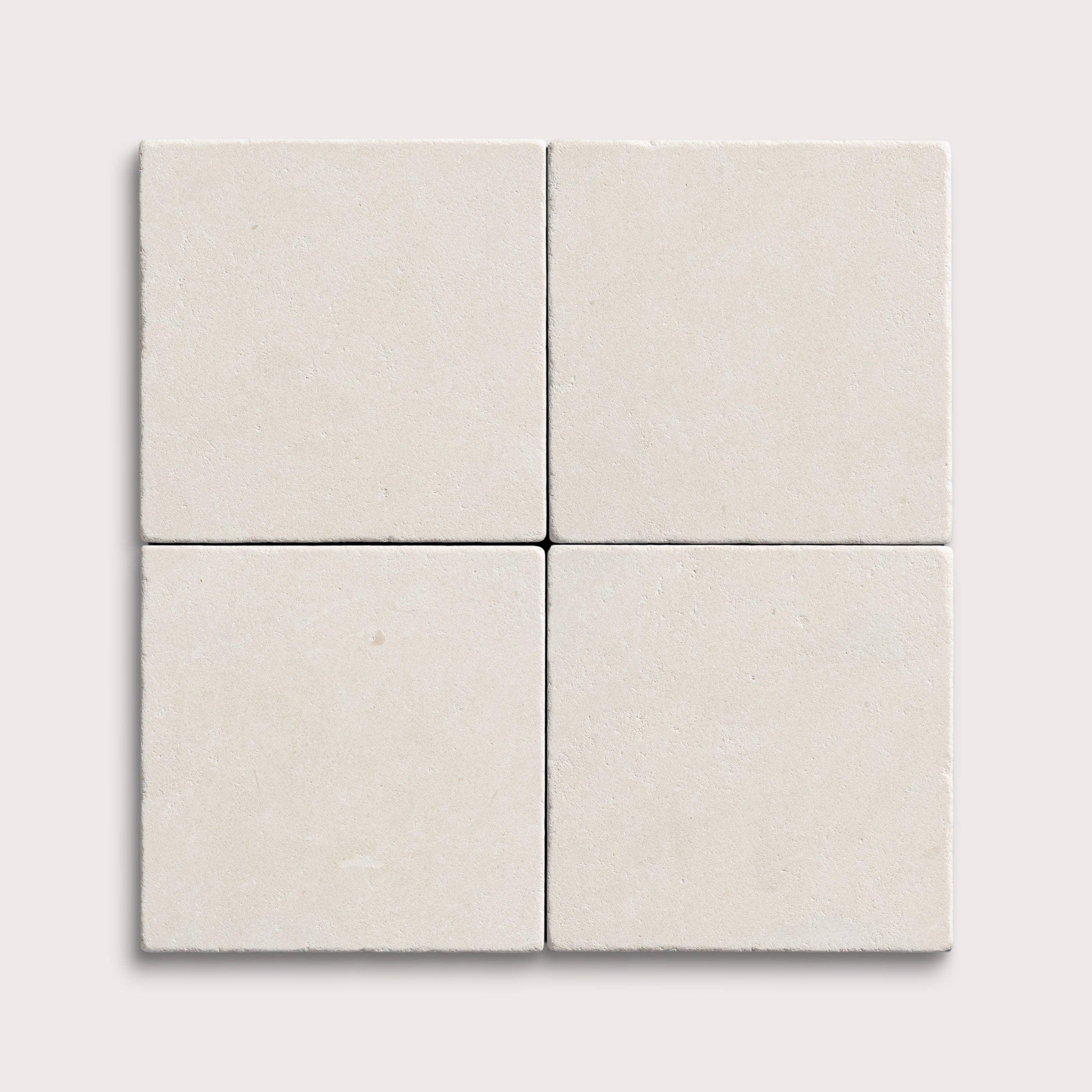 four square tiles with a white limestone pattern on a white background