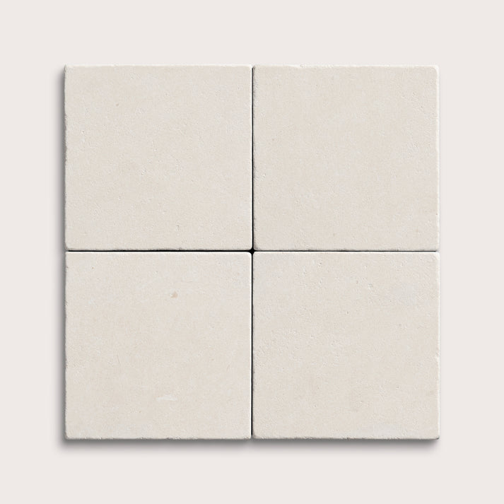 four square tiles with a white limestone pattern on a white background