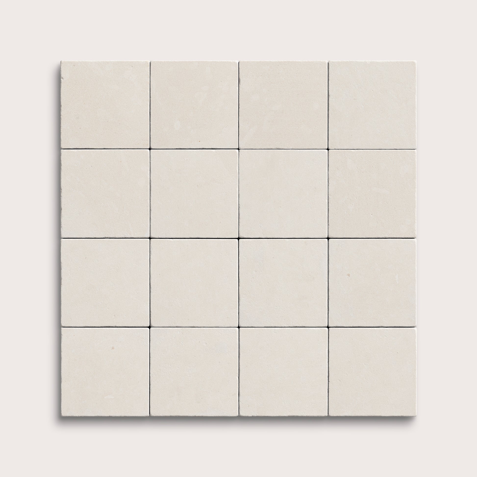 sixteen square tiles with a white limestone pattern on a white background