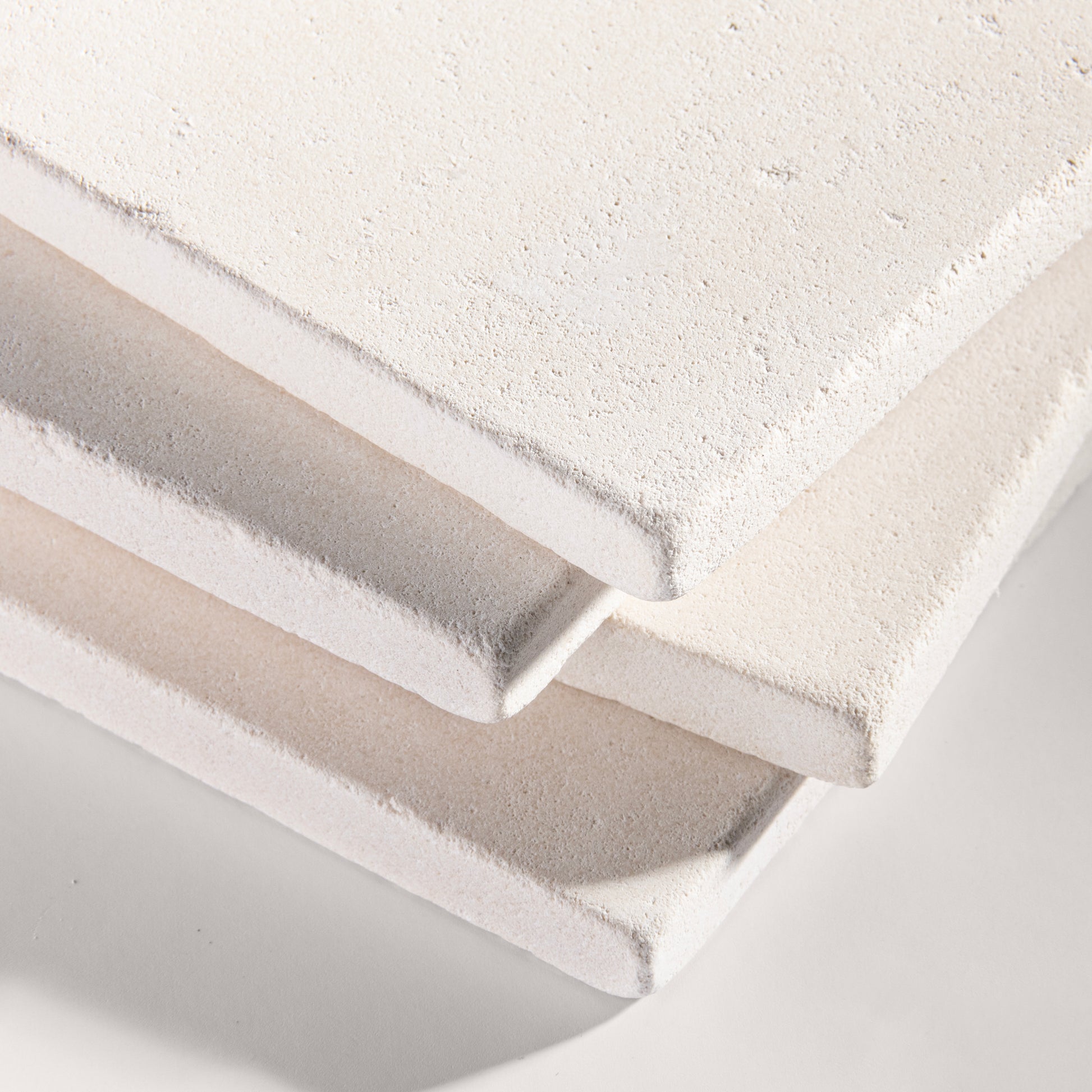 close up angle of tiles with a white limestone pattern on a white background
