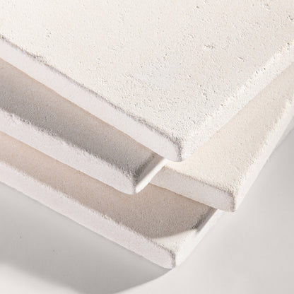 close up angle of tiles with a white limestone pattern on a white background
