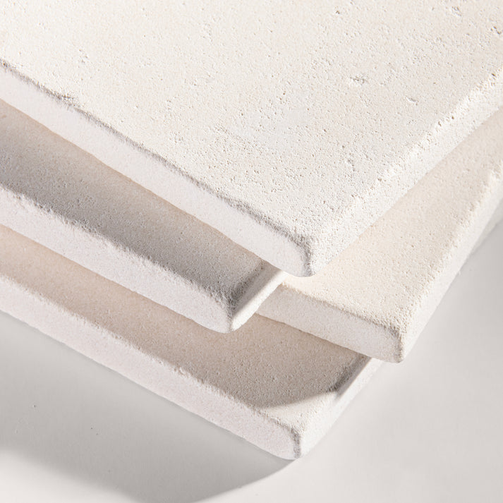 close up angle of tiles with a white limestone pattern on a white background