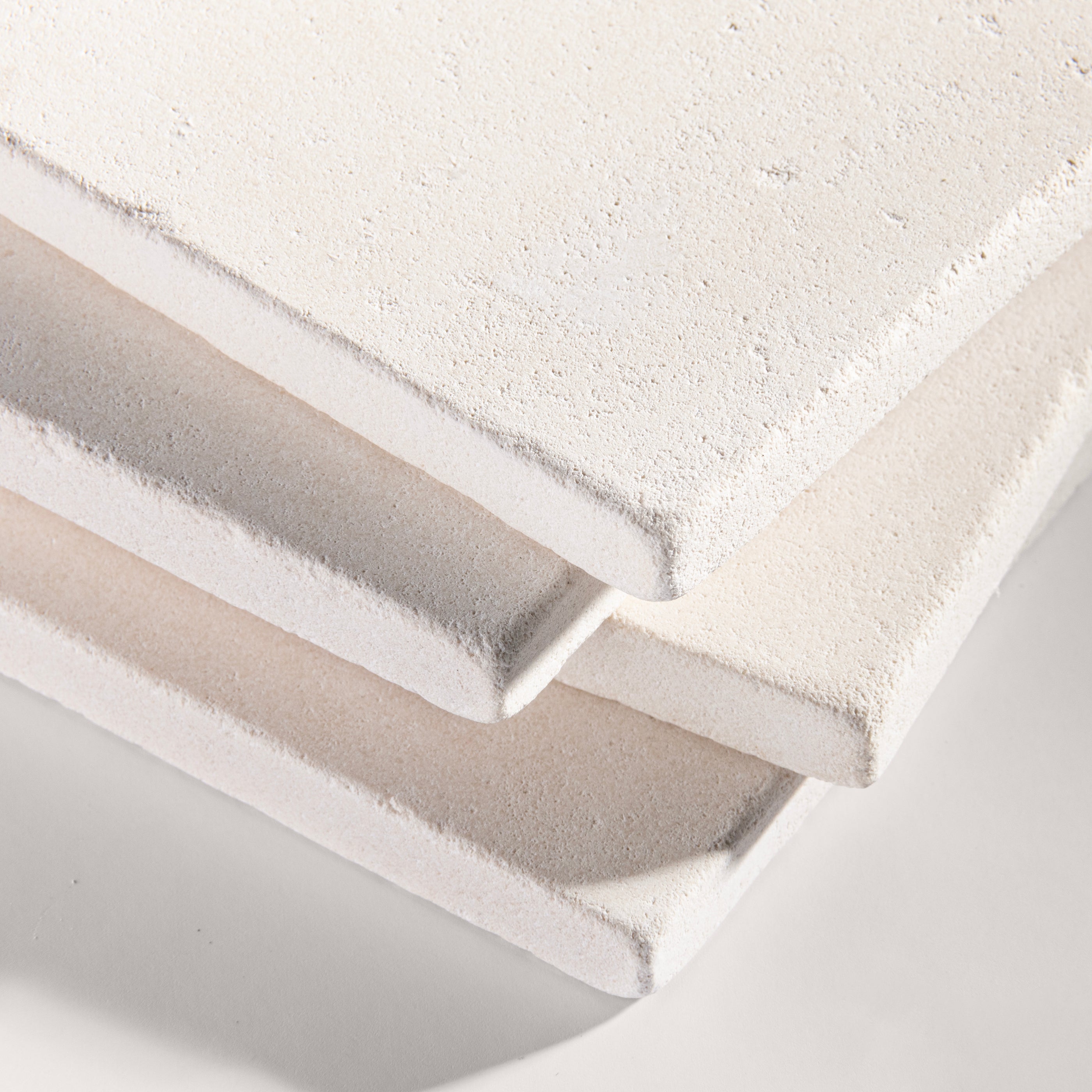 close up angle of tiles with a white limestone pattern on a white background