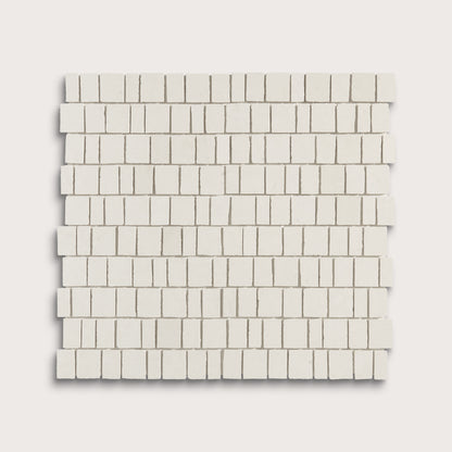 A square sample of small rectangular off-white mosaic tiles arranged in staggered rows, shown on a light warm gray background.