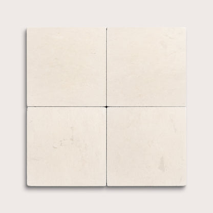 four square tiles with a beige limestone pattern on a white background