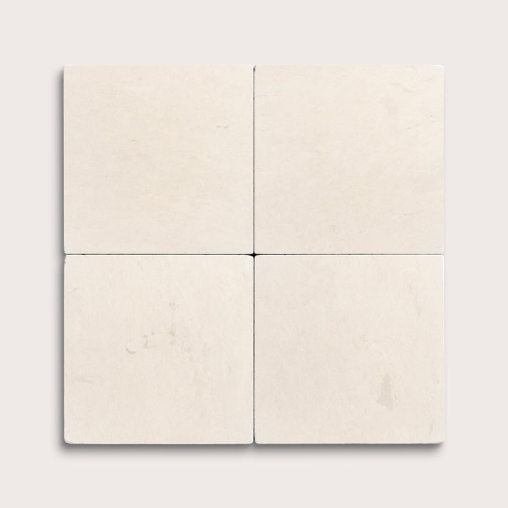 four square tiles with a beige limestone pattern on a white background