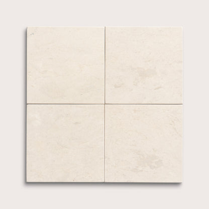 four square tiles with a beige limestone pattern on a white background
