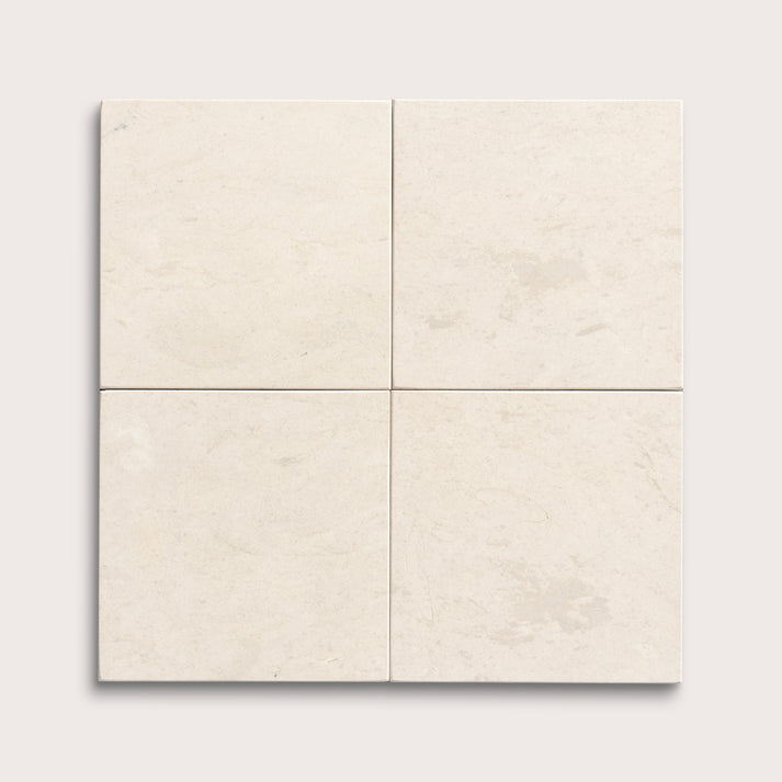 four square tiles with a beige limestone pattern on a white background