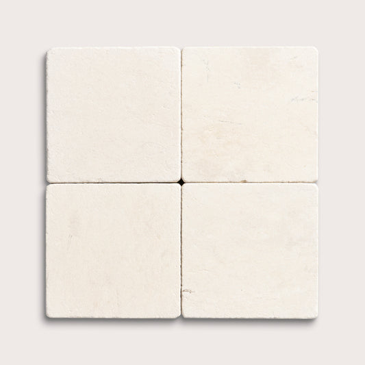 four square tiles with a beige limestone pattern on a white background