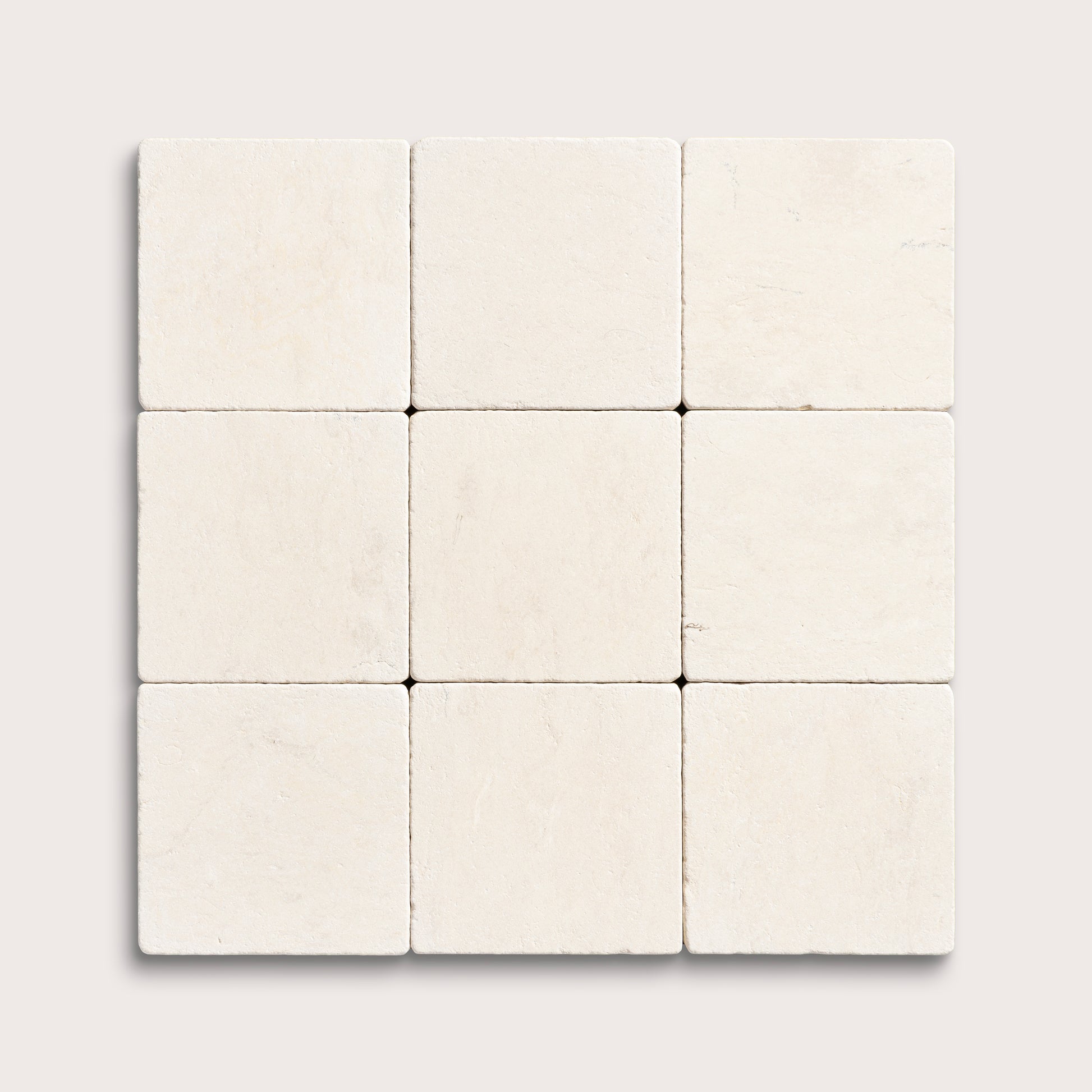 nine square tiles with a beige limestone pattern on a white background
