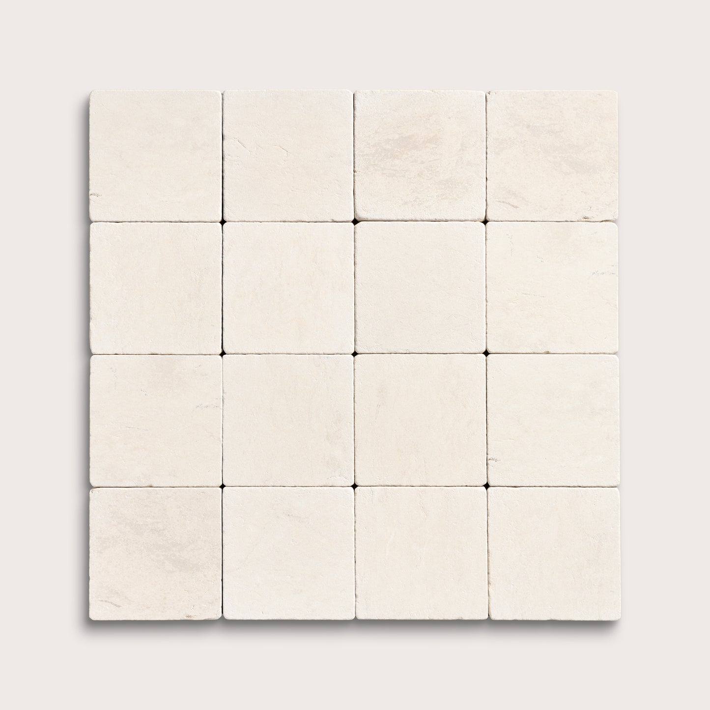 sixteen square tiles with a beige limestone pattern on a white background