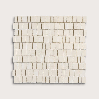 A square mosaic tile sample made of small rectangular off-white stone pieces arranged in staggered rows, shown on a light neutral background.