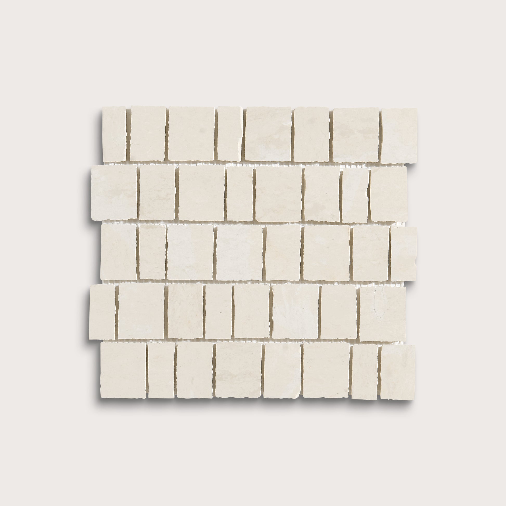 A square sample of small rectangular off-white stone mosaic tiles arranged in staggered rows on a light neutral background.