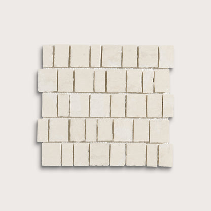 A square sample of small rectangular off-white stone mosaic tiles arranged in staggered rows on a light neutral background.