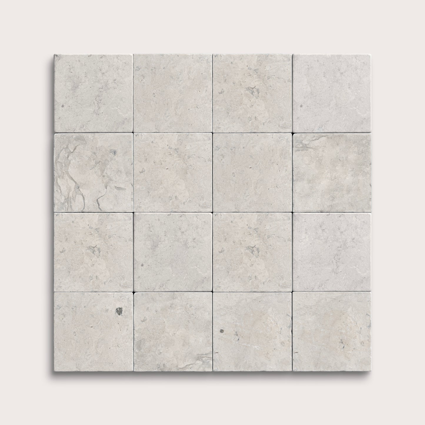 Square limestone tiles with a gray, textured pattern on a white background