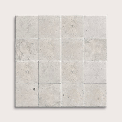 Square limestone tiles with a gray, textured pattern on a white background