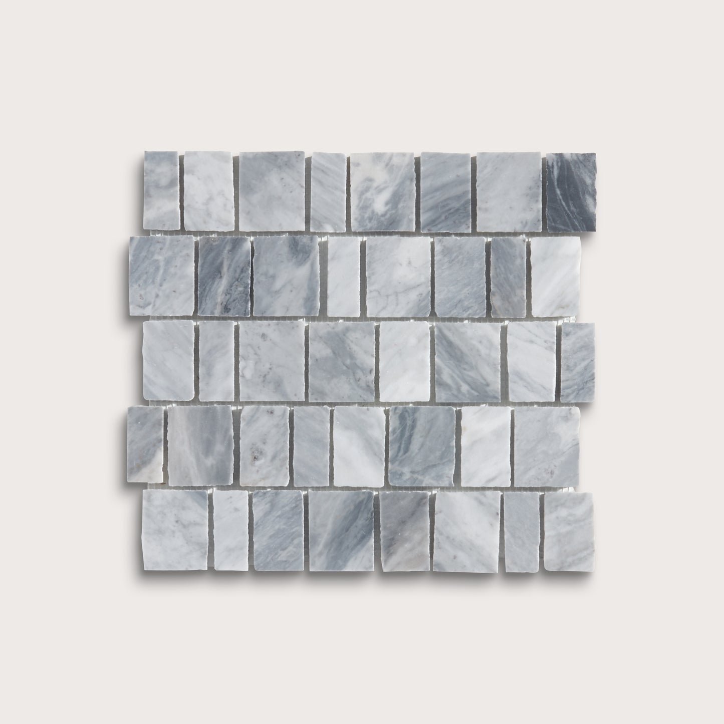 A rectangular mosaic tile sample made of small gray marble-like blocks arranged in staggered rows, shown on a light warm gray background.