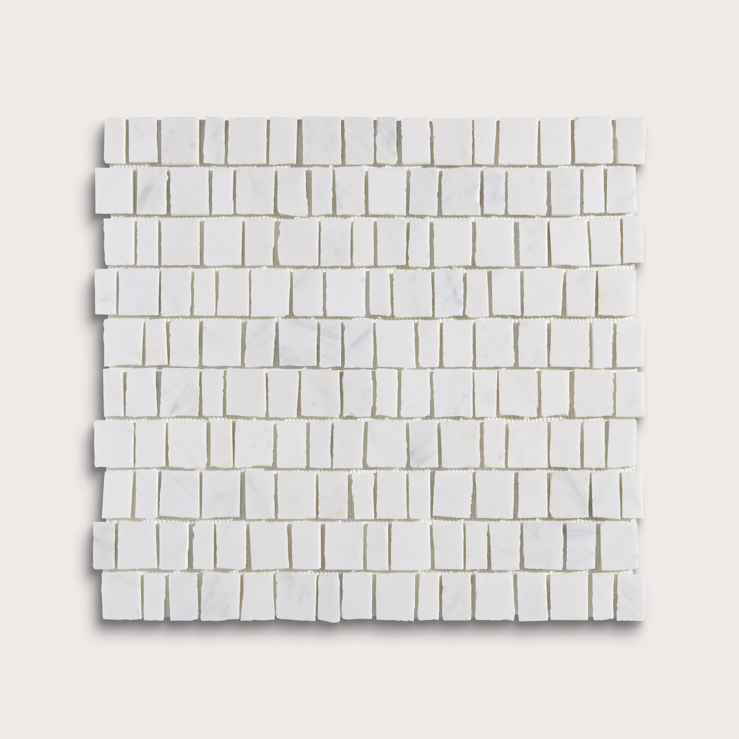 White marble rectangular mosaic tile sheet arranged in a staggered brick pattern, shown against a light beige background.