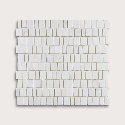 White marble rectangular mosaic tile sheet arranged in a staggered brick pattern, shown against a light beige background.