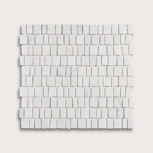 White marble rectangular mosaic tile sheet arranged in a staggered brick pattern, shown against a light beige background.