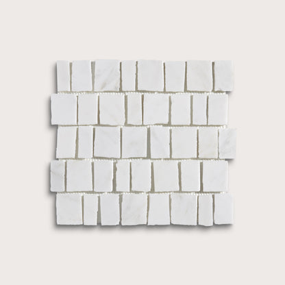 White marble rectangular mosaic tile sheet arranged in a staggered brick pattern, shown on a light beige background.