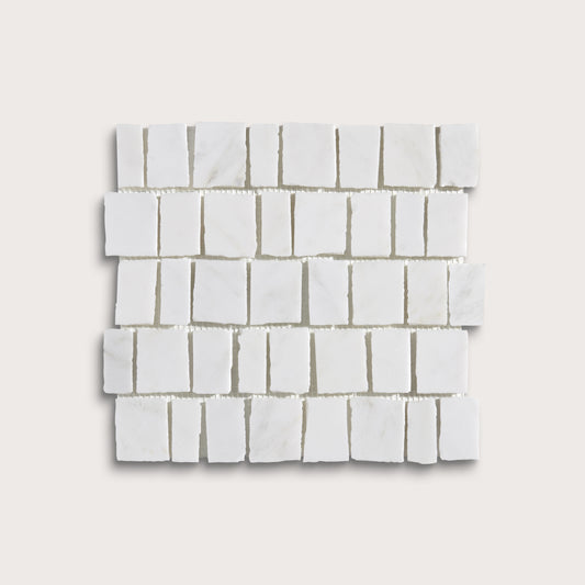 White marble rectangular mosaic tile sheet arranged in a staggered brick pattern, shown on a light beige background.