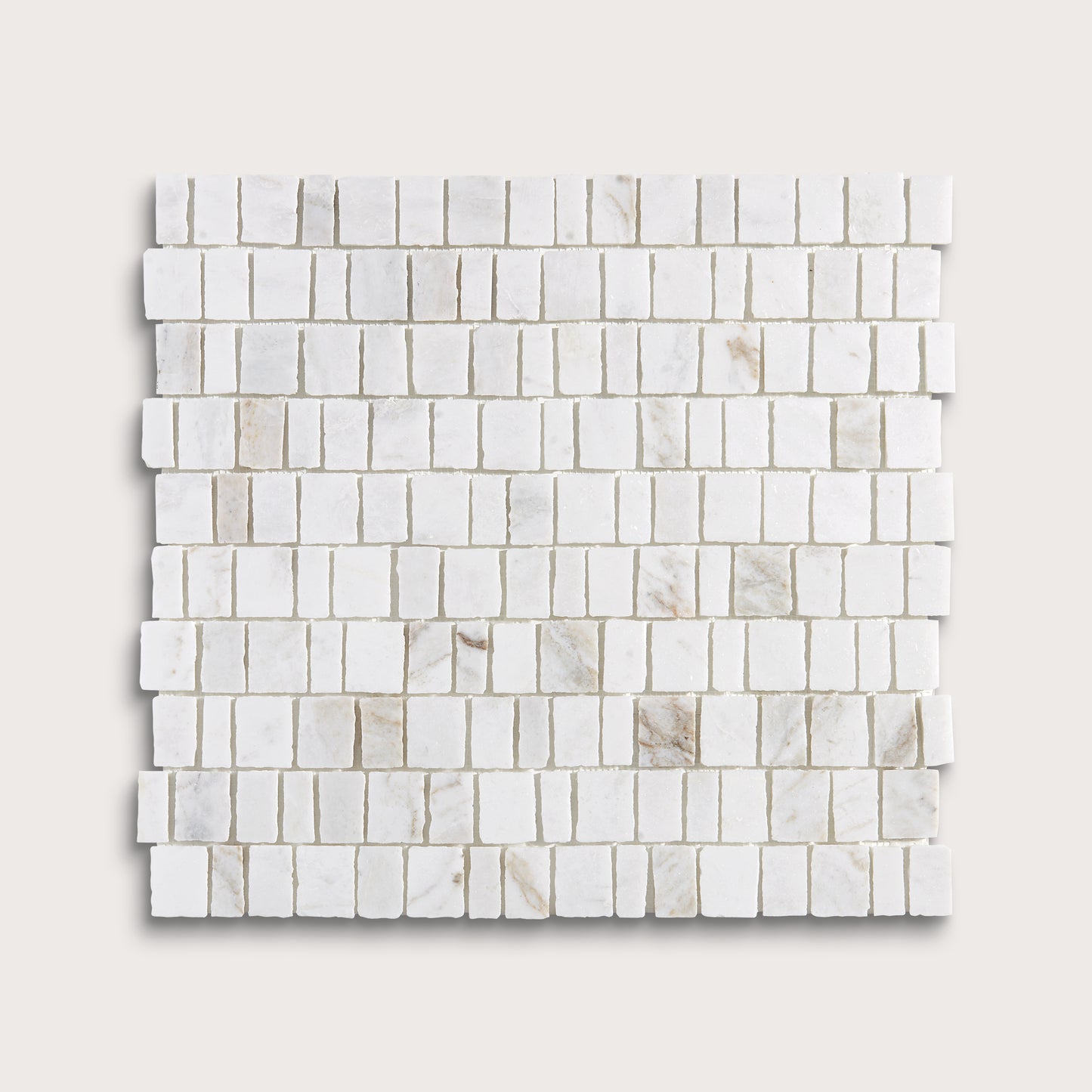 A square sample of white marble mosaic tile in a brick or running bond pattern, shown on a light beige background.