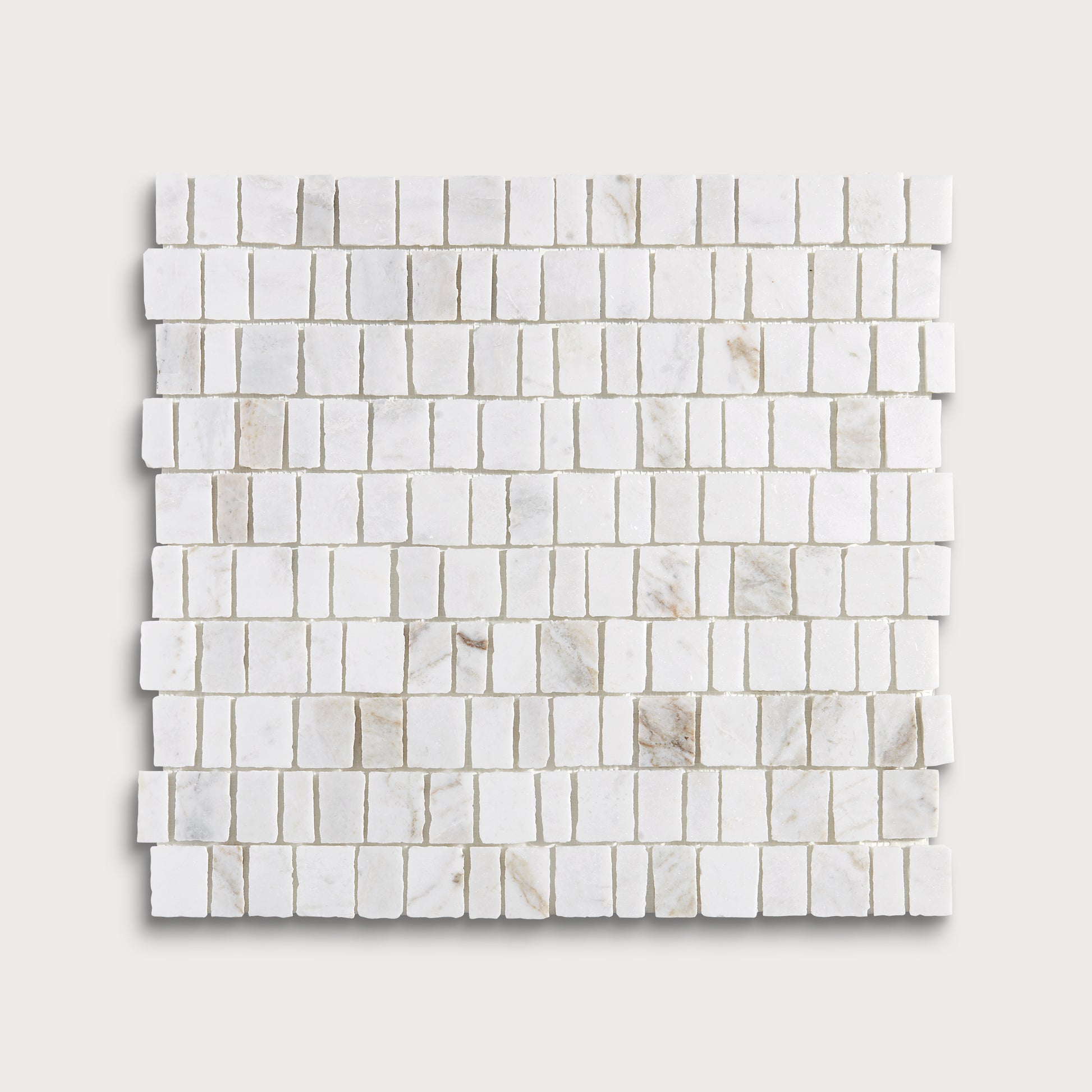 A square sample of white marble mosaic tile in a brick or running bond pattern, shown on a light beige background.