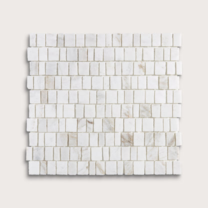 A square sample of white marble mosaic tile in a brick or running bond pattern, shown on a light beige background.