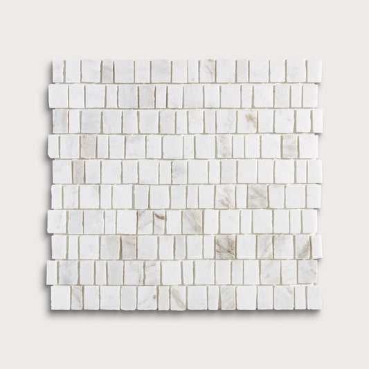 A square sample of white marble mosaic tile in a brick or running bond pattern, shown on a light beige background.