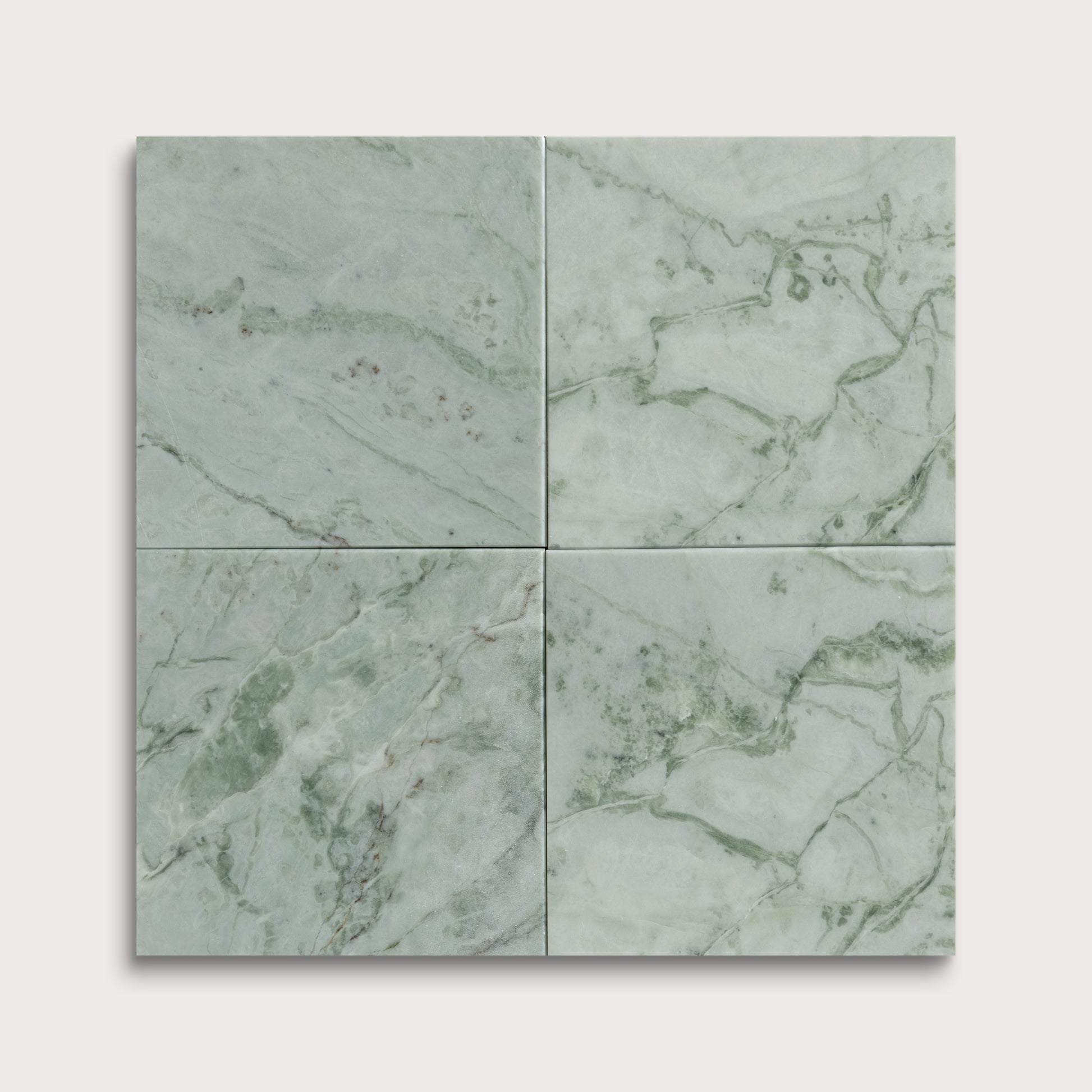Four green marble tiles arranged in a grid pattern on a light gray background