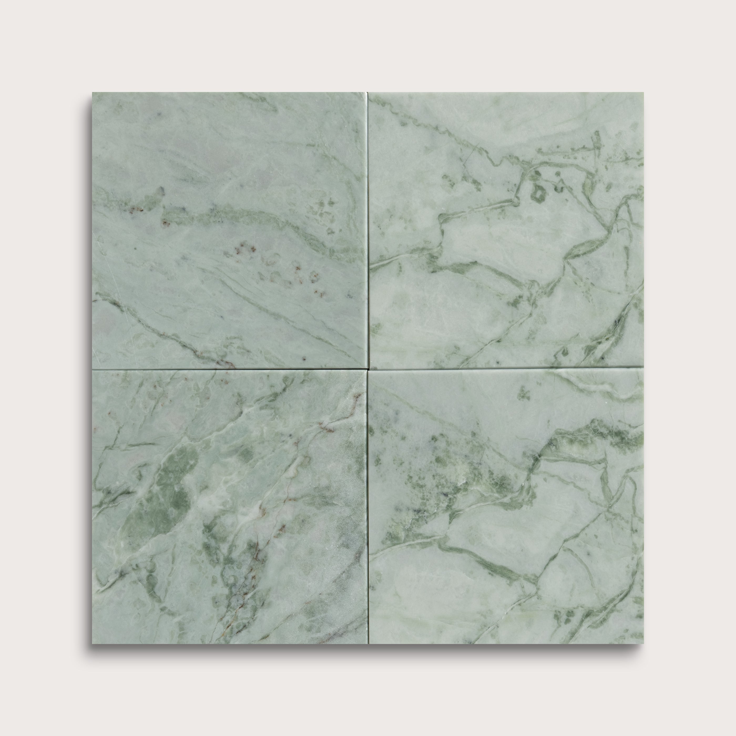 Four green marble tiles arranged in a grid pattern on a light gray background