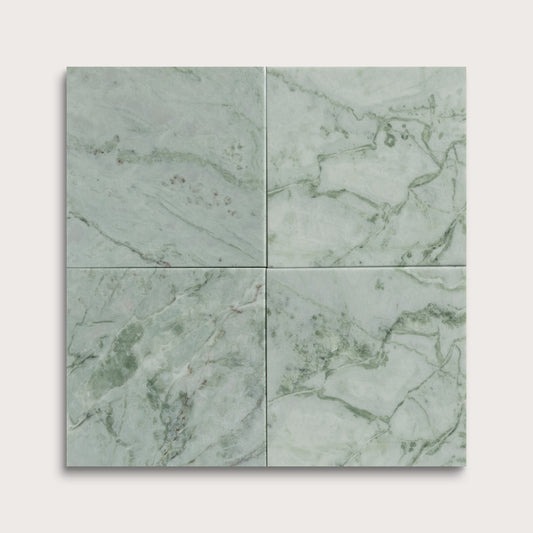Four green marble tiles arranged in a grid pattern on a light gray background