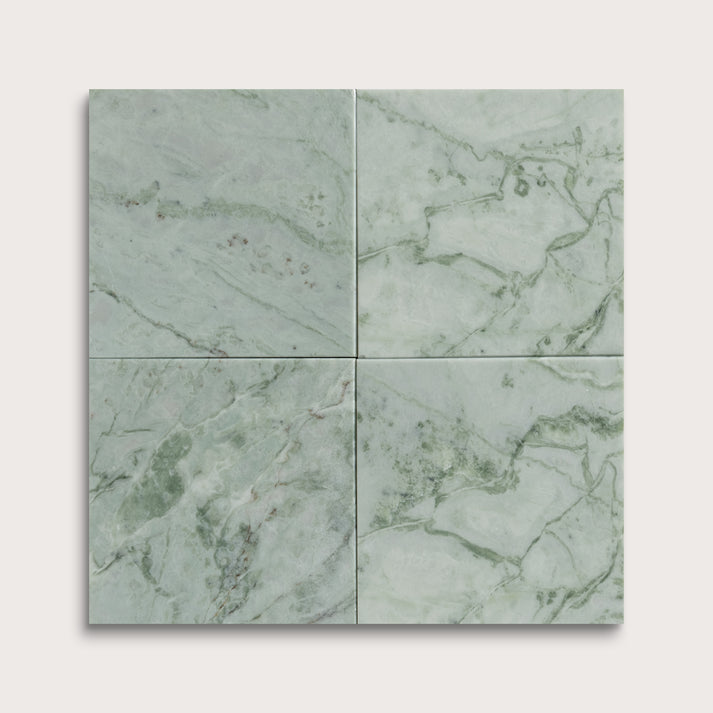 Four green marble tiles arranged in a grid pattern on a light gray background