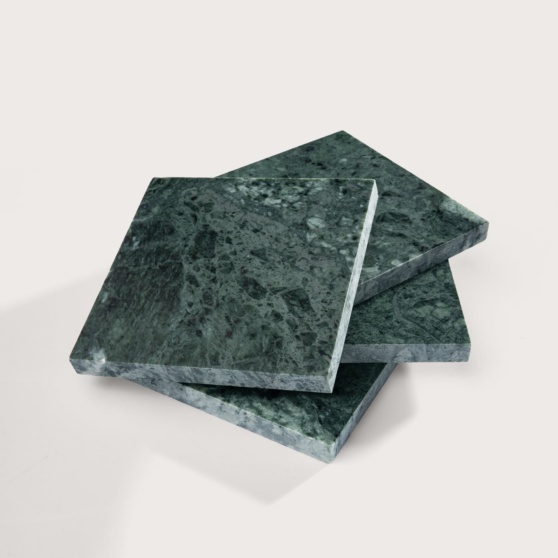 Three green marble tiles stacked on a light gray background