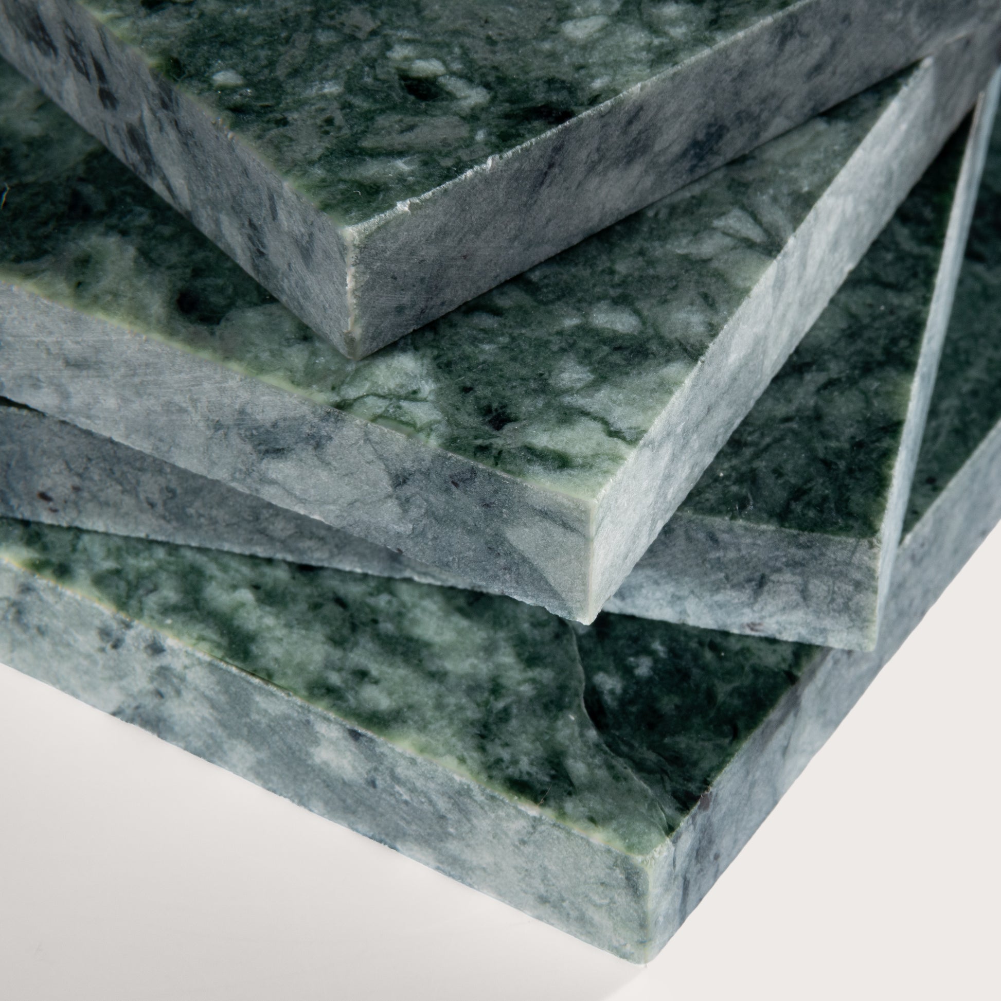 Stack of green marble slabs on a white background
