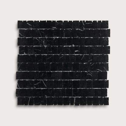 A square sample of black marble mosaic tiles with natural white veining, arranged in a grid pattern against a light gray background.