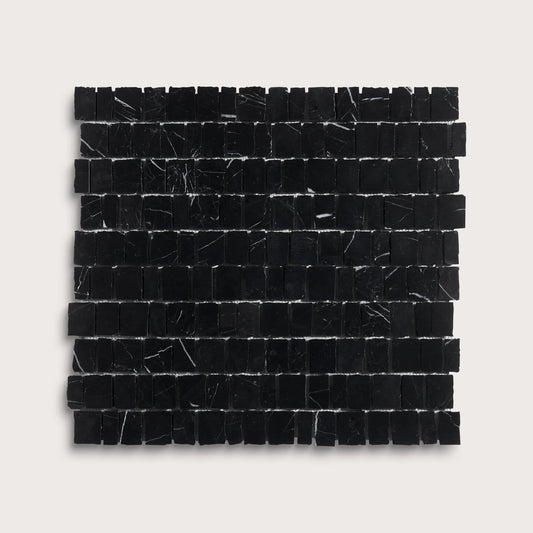 A square sample of black marble mosaic tiles with natural white veining, arranged in a grid pattern against a light gray background.