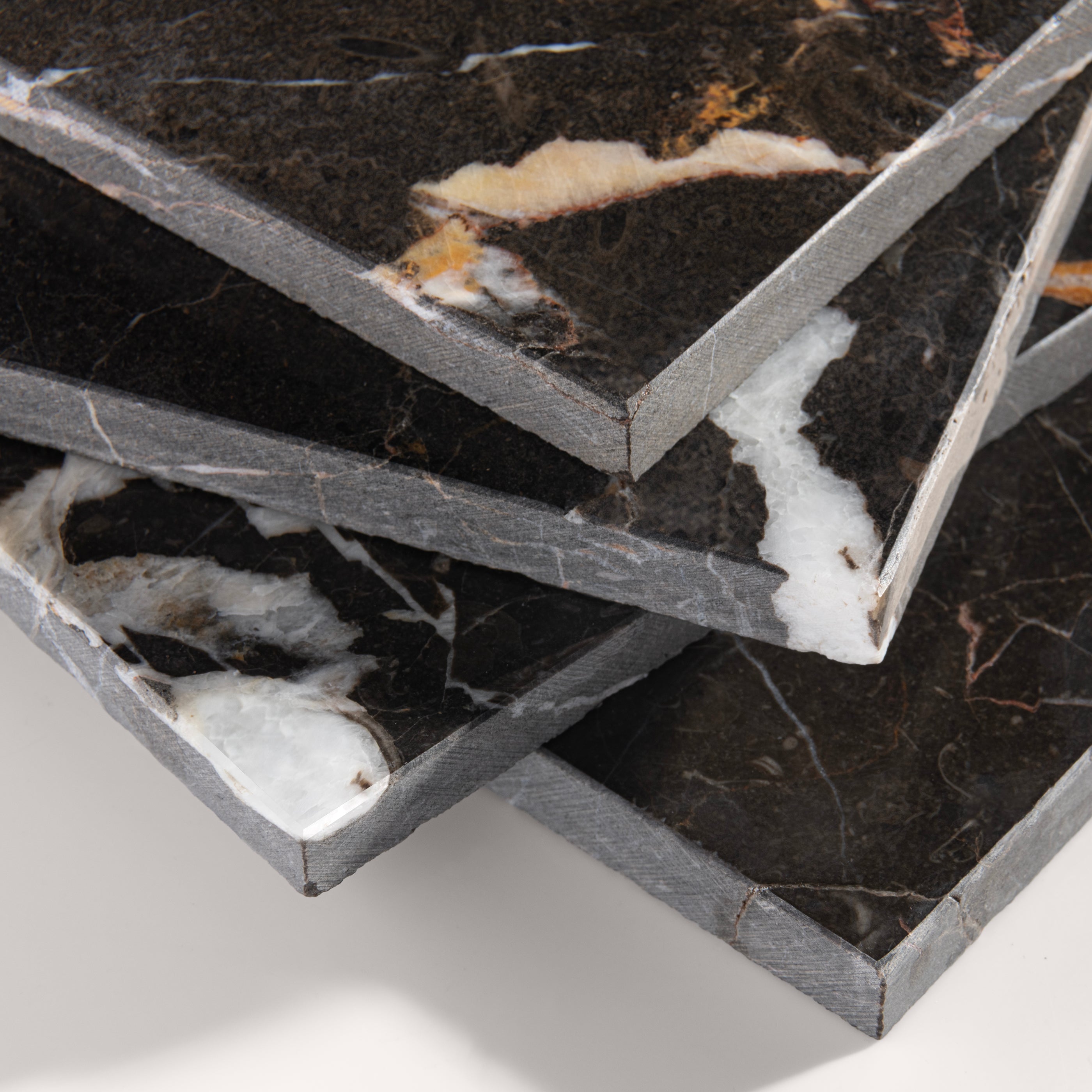 close up angle of brown marble tiles with visible veins on a white background