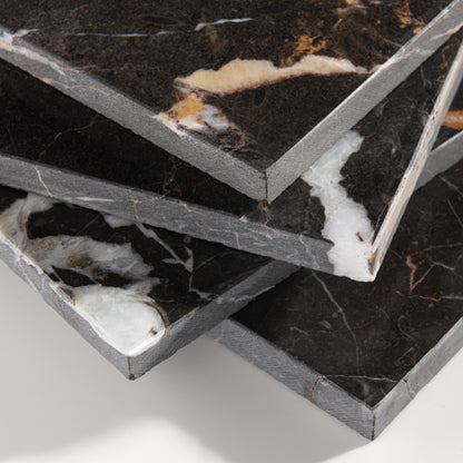 close up angle of brown marble tiles with visible veins on a white background
