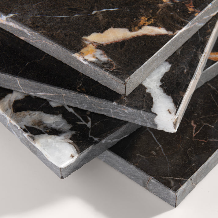 close up angle of brown marble tiles with visible veins on a white background