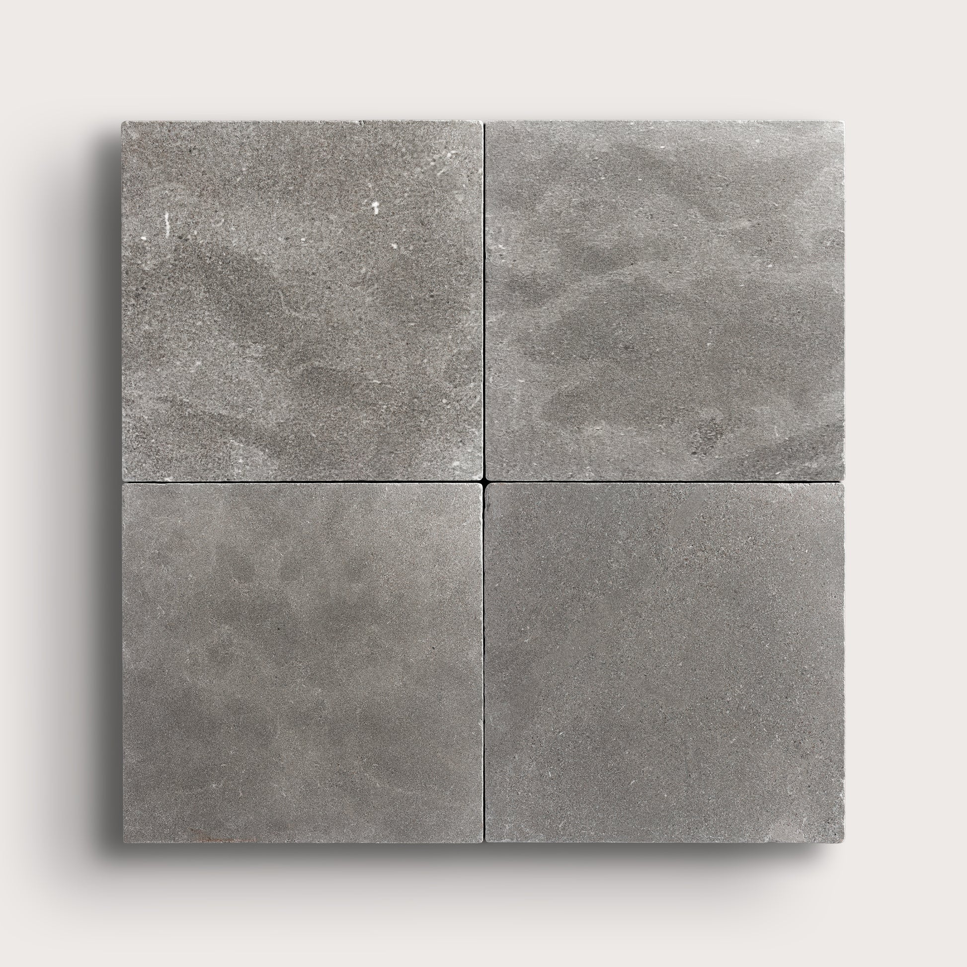 grey square limestone tile in grid pattern on a light grey background