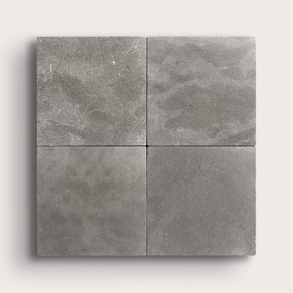 grey square limestone tile in grid pattern on a light grey background