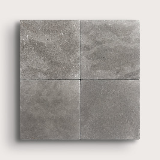grey square limestone tile in grid pattern on a light grey background