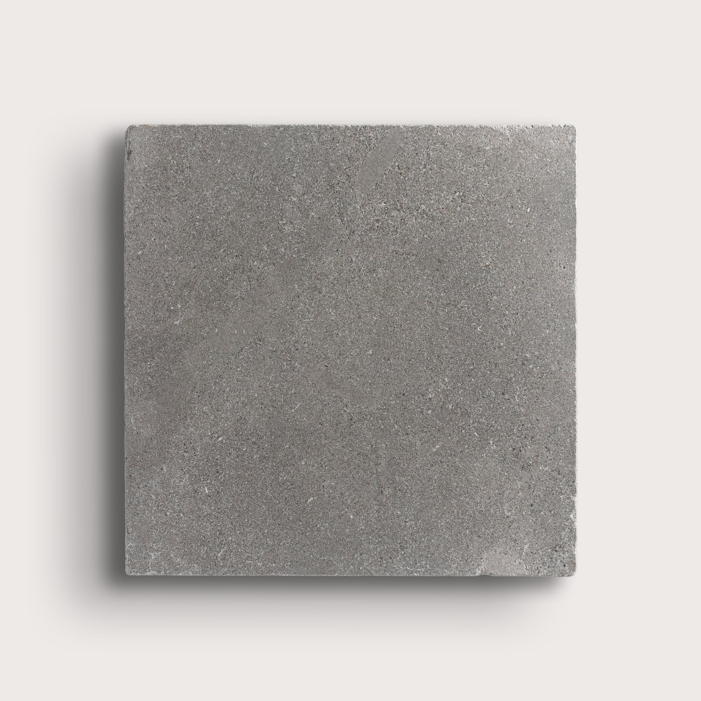 grey square limestone tile on a light grey background