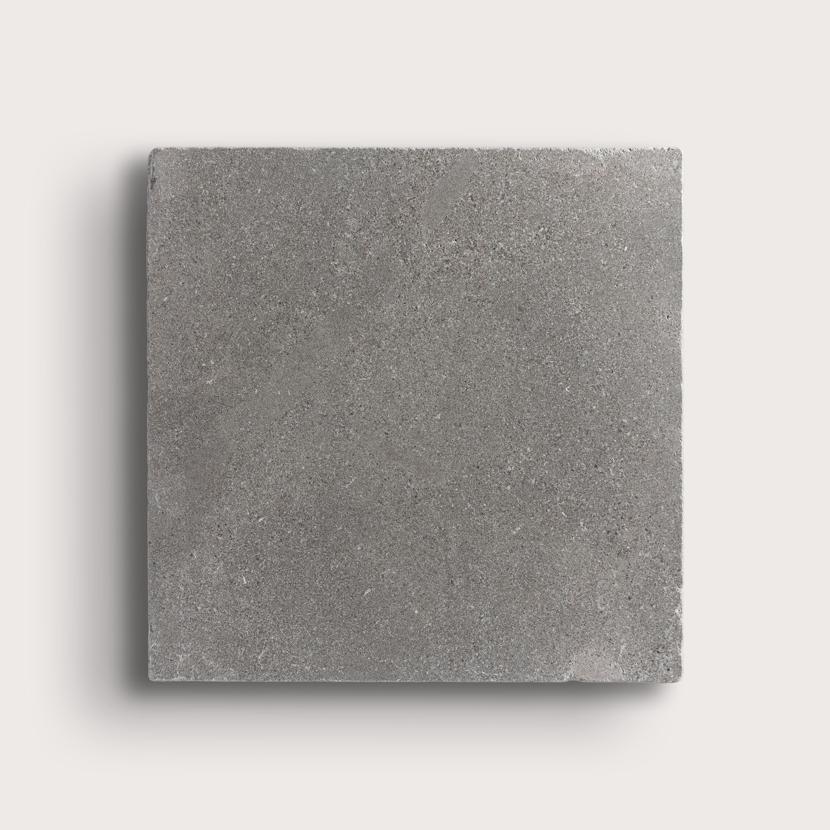 grey square limestone tile on a light grey background