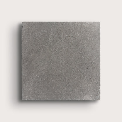 grey square limestone tile on a light grey background